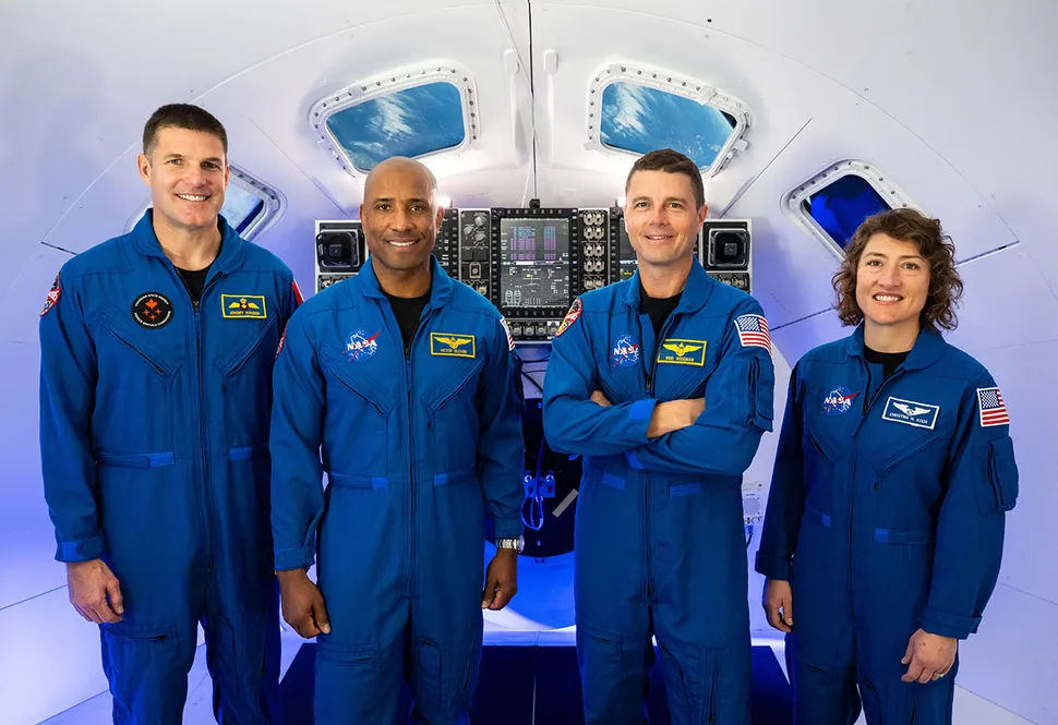 A tripulação da Artemis II, incluindo o astronauta da Agência Espacial Canadense Jeremy Hansen (à esquerda) e os astronautas da NASA Victor Glover, Reid Wiseman e Christina Koch, posam juntos em um simulador da espaçonave Orion no Centro Espacial Johnson. (Créditos: James Blair/via NASA)