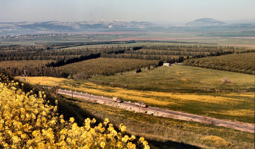 Planície de Jezreel vista de Megido. Ao longe, estendendo-se pela colina, está a cidade de Nazaré. Ao fundo, à direita da foto, vê-se o alto monte circular do Monte Tabor, próximo ao local onde Débora derrotou Sísera (Juízes 4:5). (Créditos: David Bivin/via BiblePlaces)