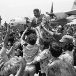 Uma multidão levanta o comandante do esquadrão de resgate dos aviões em seu retorno a Israel. (Créditos: David Rubinger/Corbis/via Getty Images)