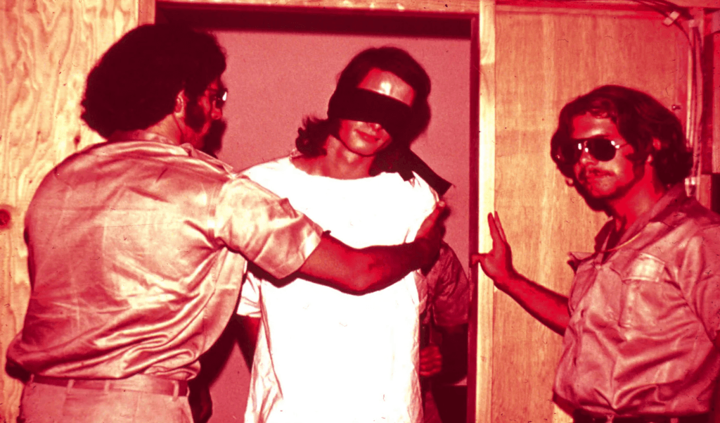 Guardas com um prisioneiro durante o Experimento da Prisão de Stanford. (Créditos: PrisonExp.org)