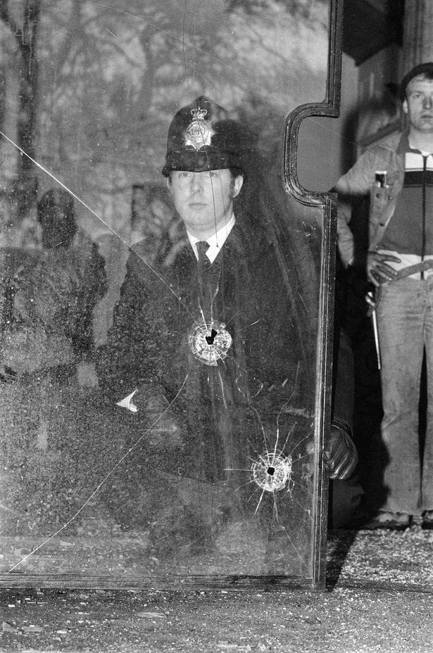 Policial analisa as balas no interior da embaixada. (Reprodução: Google)